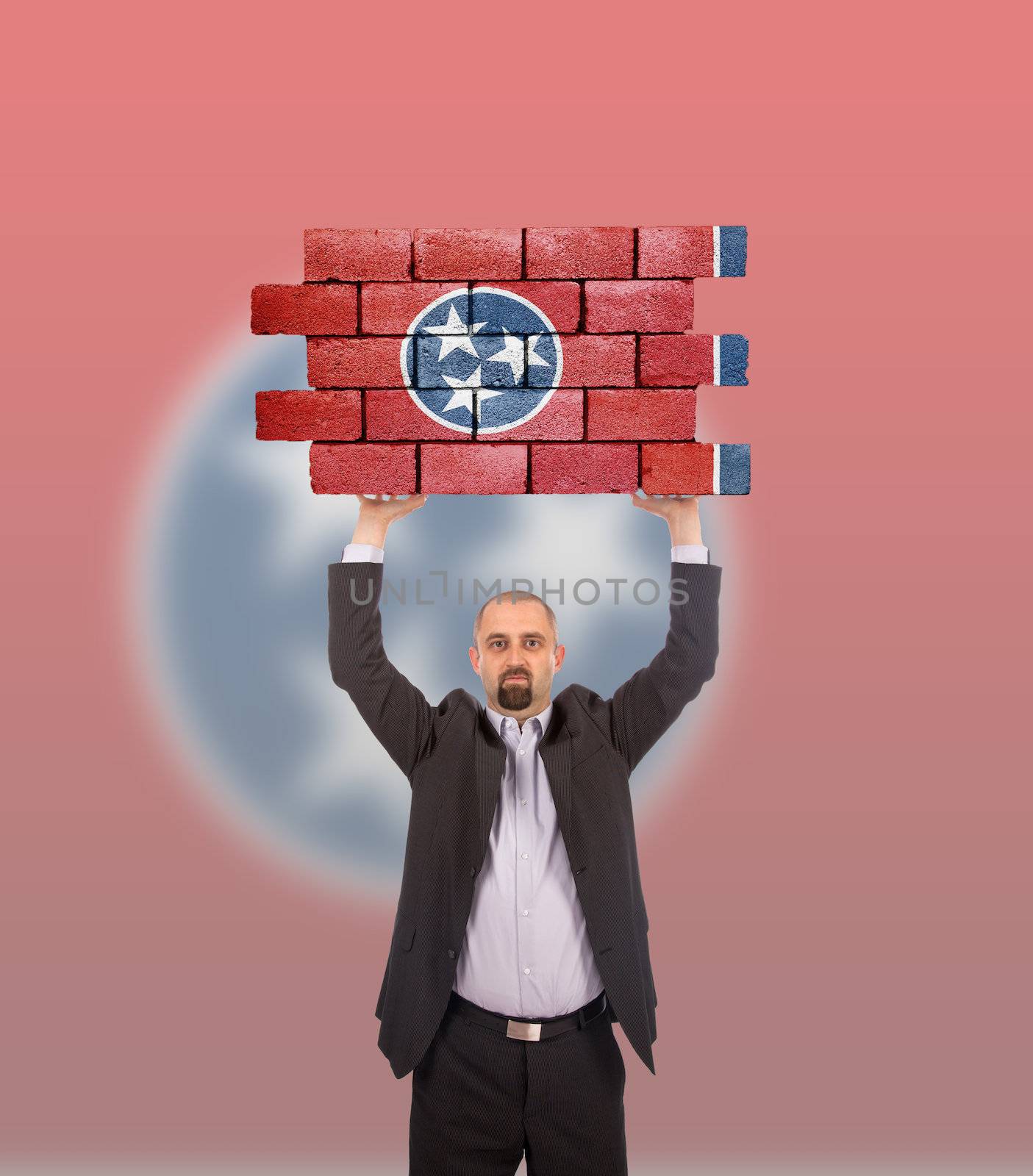 Businessman holding a large piece of a brick wall, flag of Tennessee, isolated on national flag