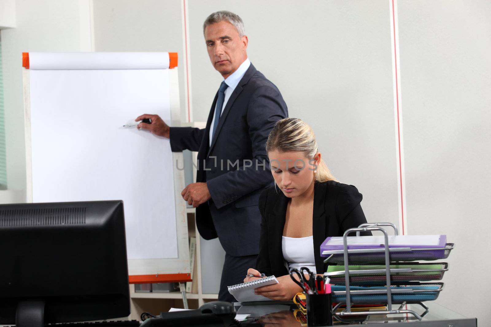 Businessman stood by flip-chart