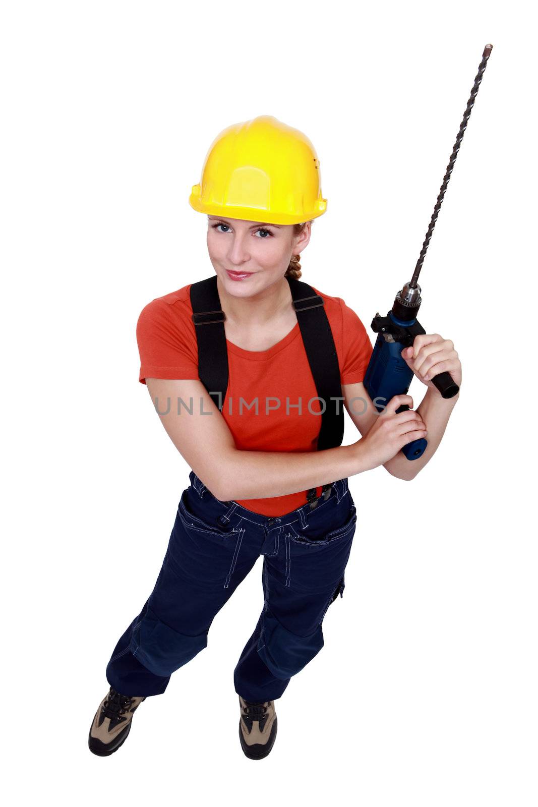 Tradeswoman holding a power tool by phovoir