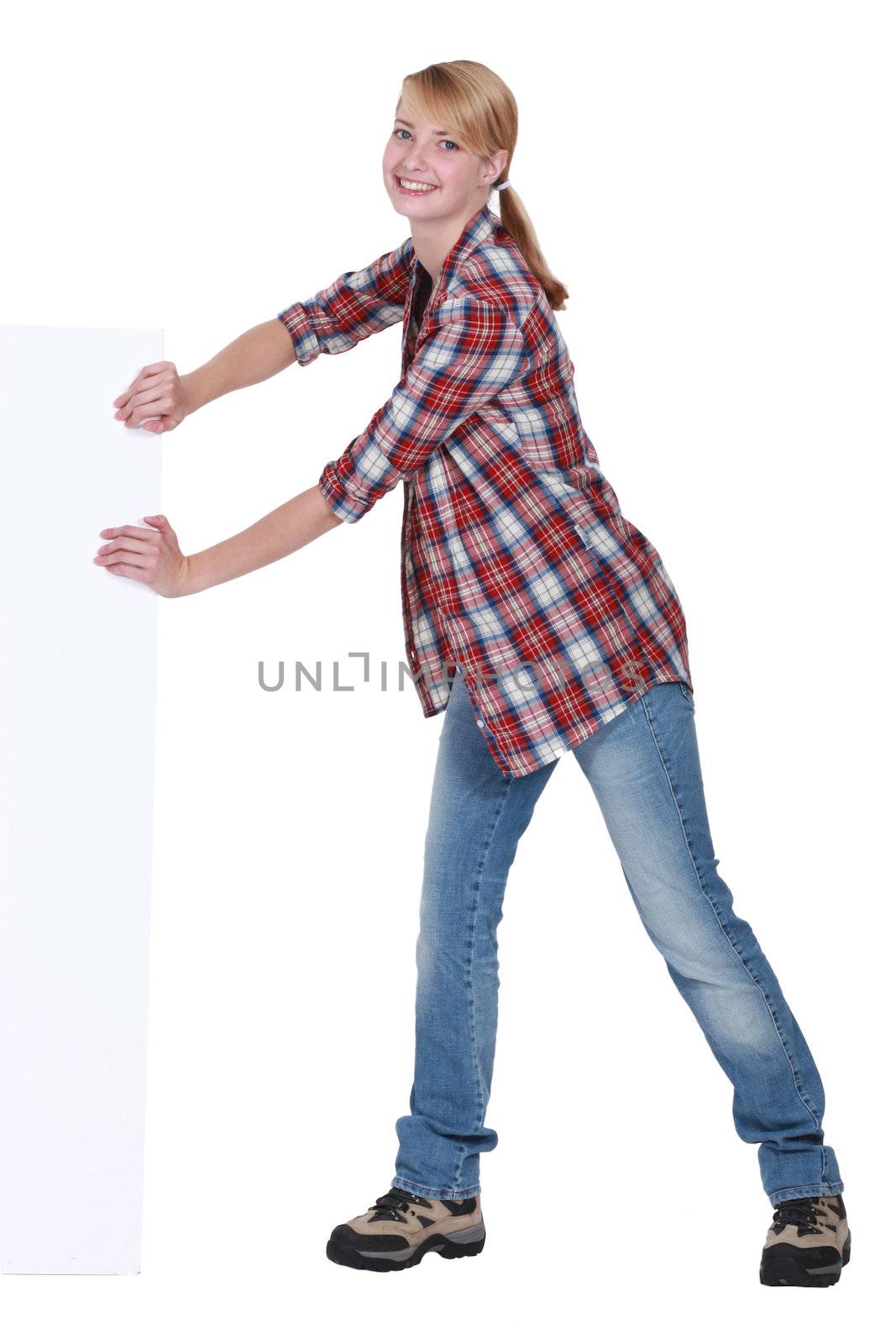 Woman pushing against blank poster