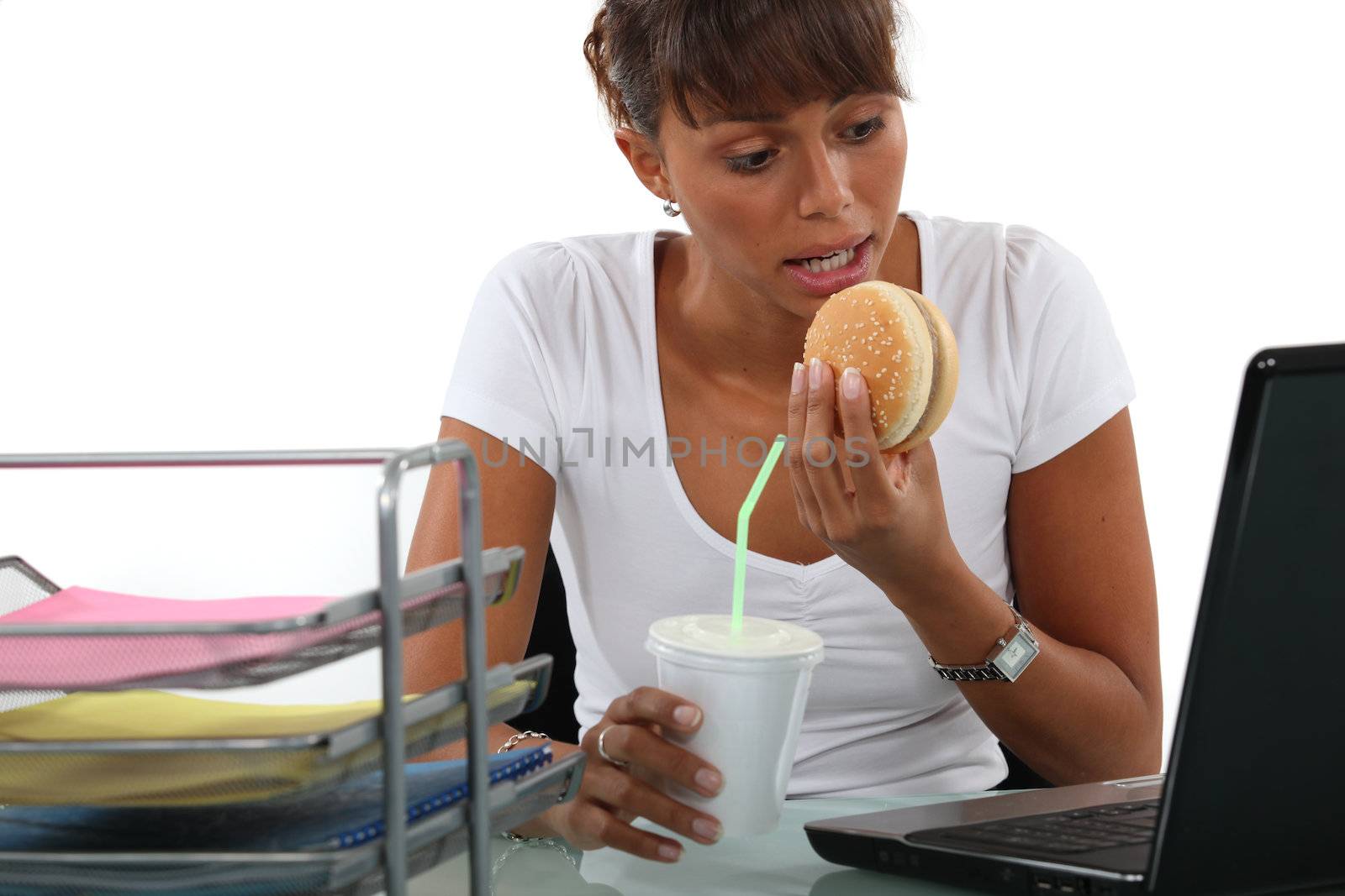 Office worker having a quick lunch in front of her computer by phovoir