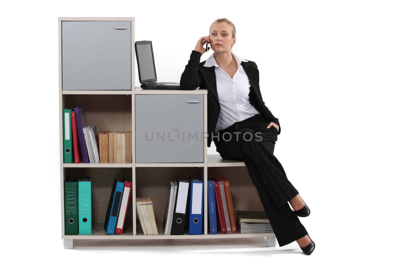 Woman sitting on a bookcase by phovoir