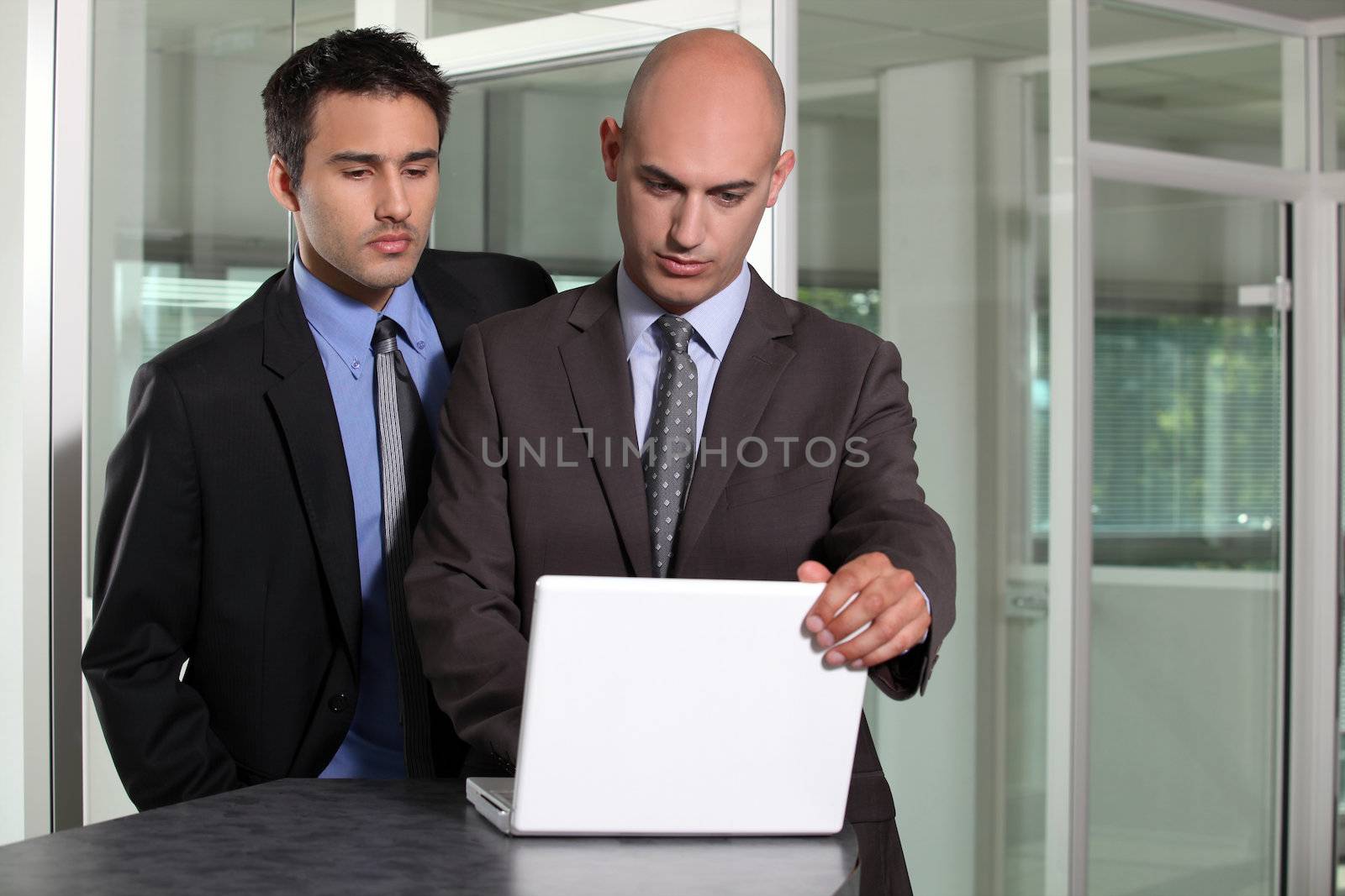 Two businessmen in hallway by phovoir