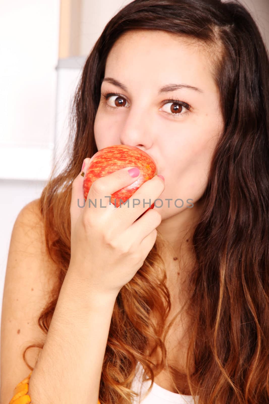 A young adult woman eating a Apple.