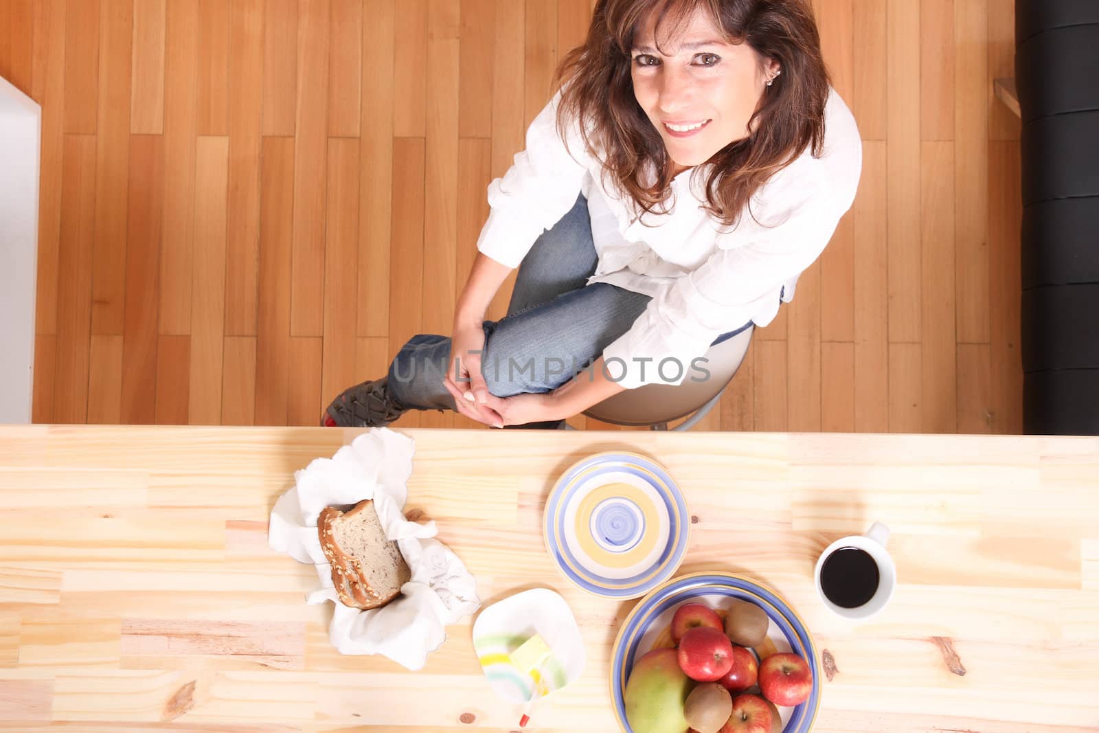 Portrait of a beautiful mature woman sitting in the kitchen.