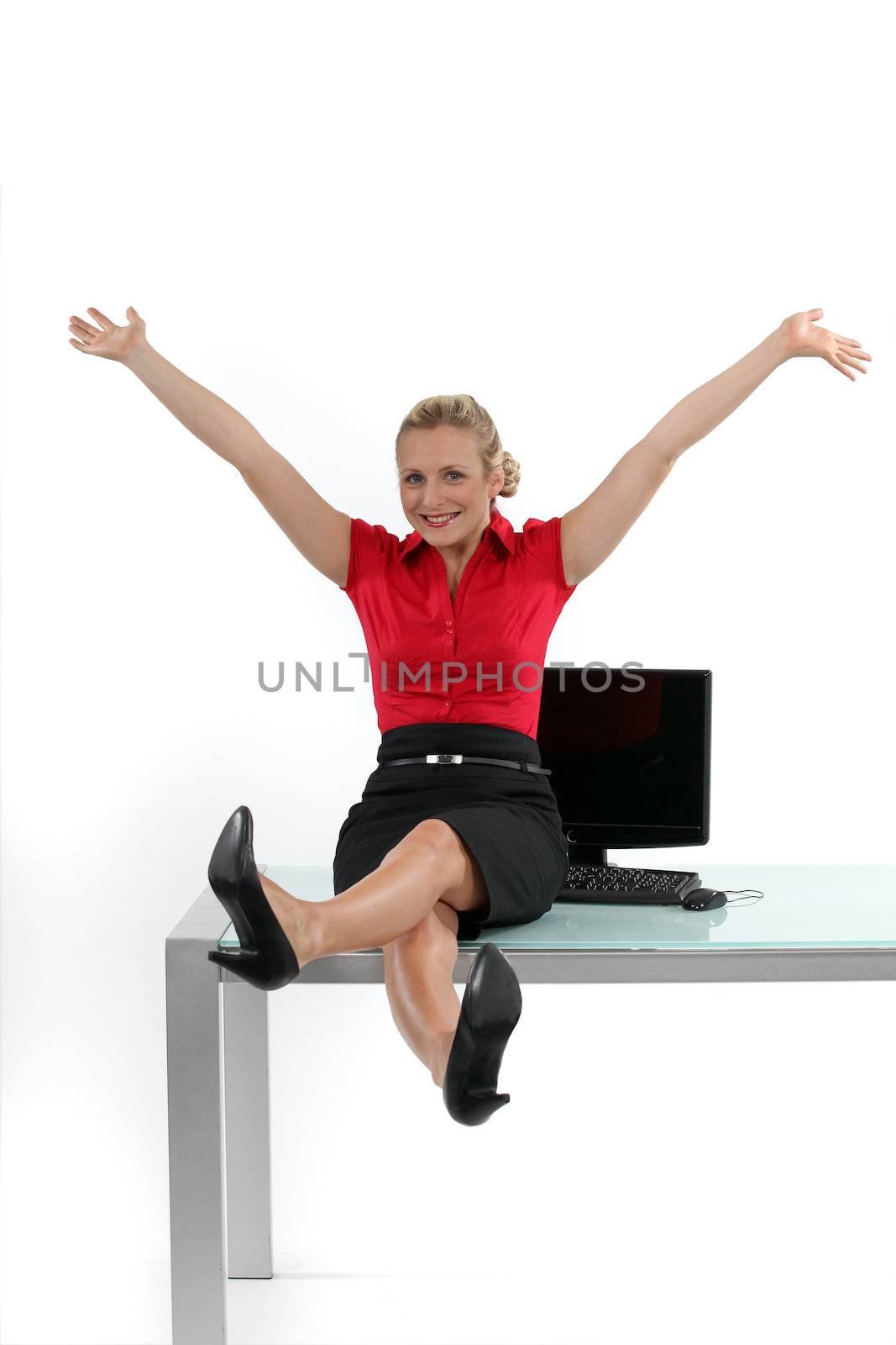 Relaxed woman sitting on her desk by phovoir