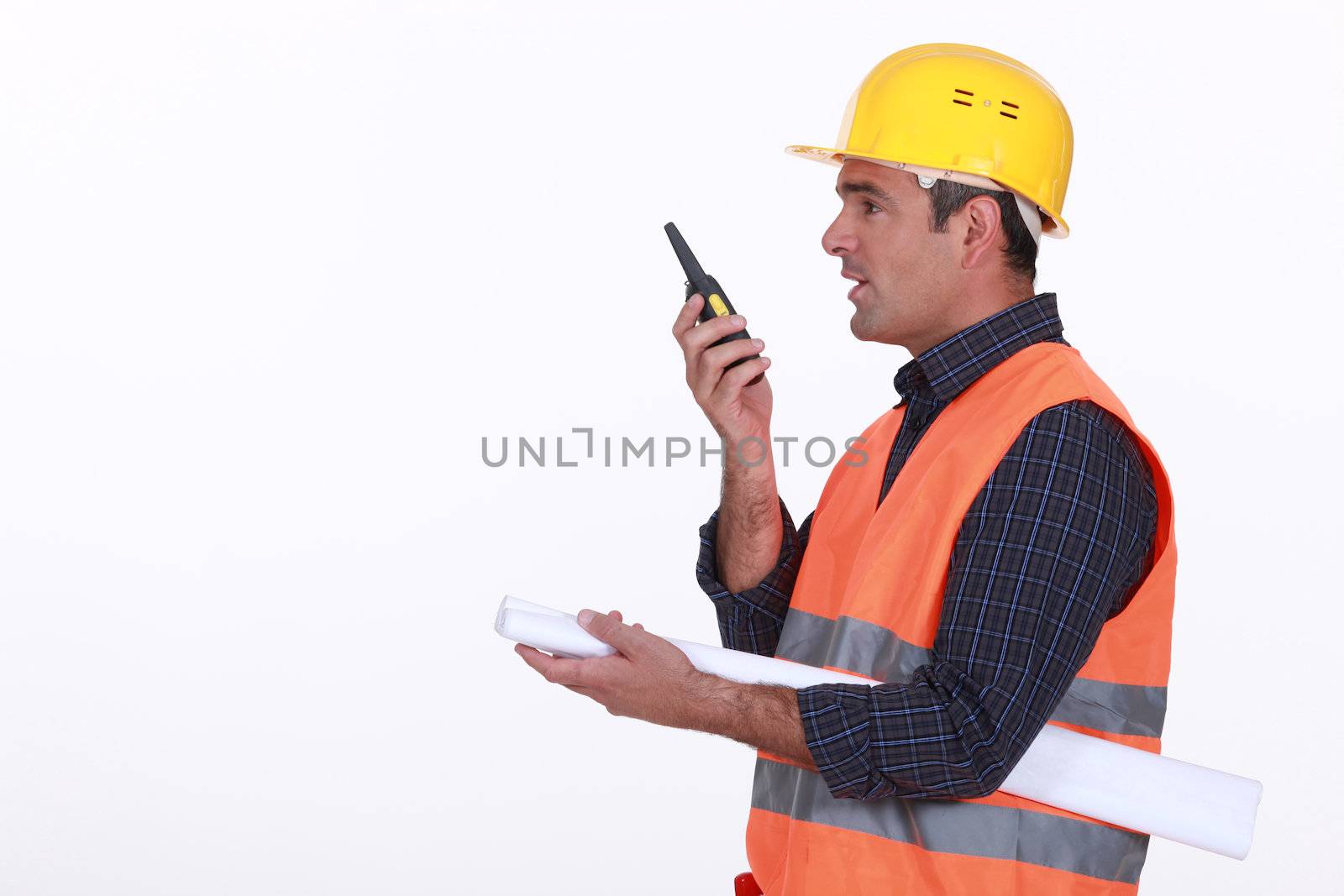 construction site supervisor talking on his walkie talkie by phovoir