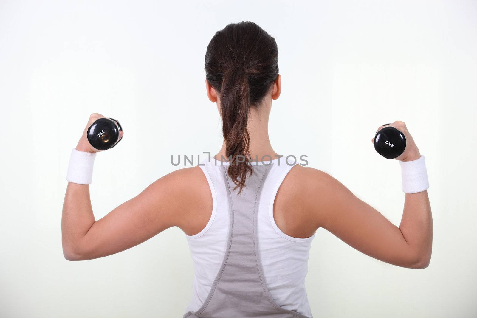 Woman lifting weights by phovoir