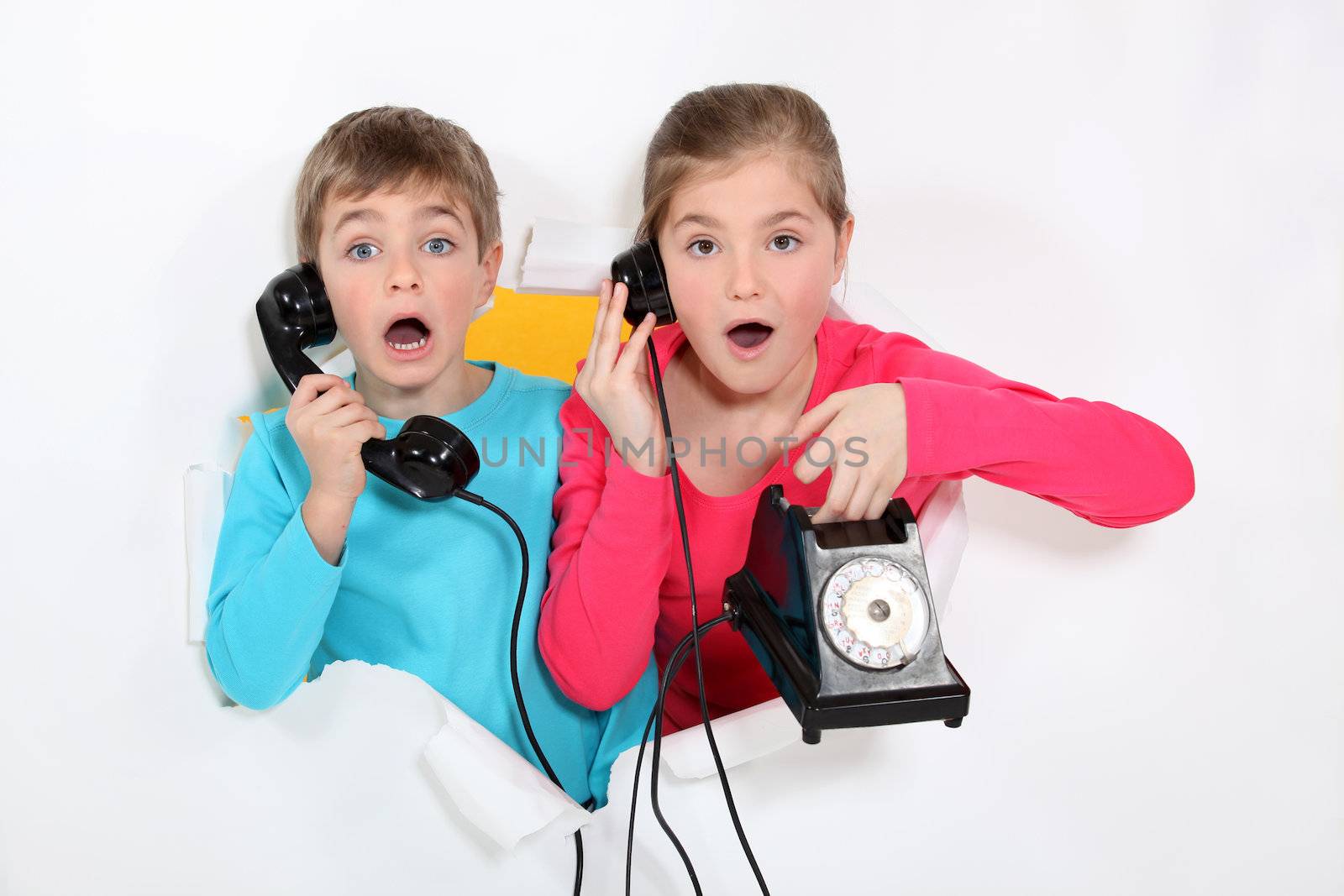 Brother and sister using old telephone