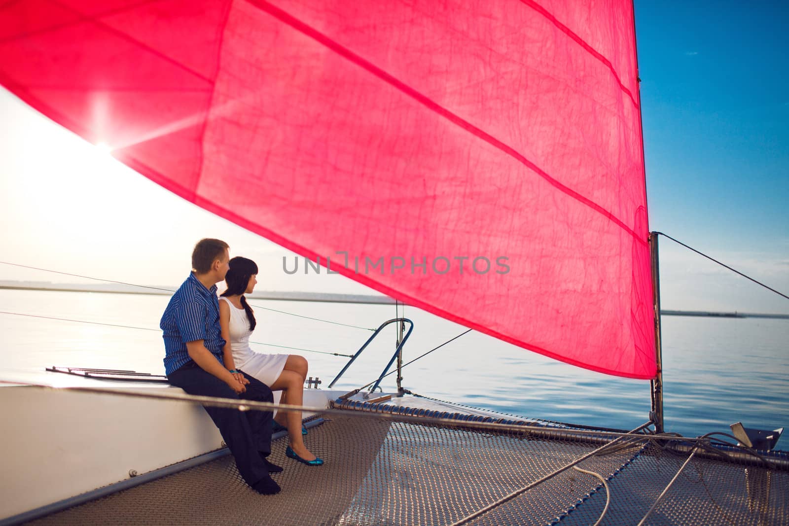 man and girl under the red sail