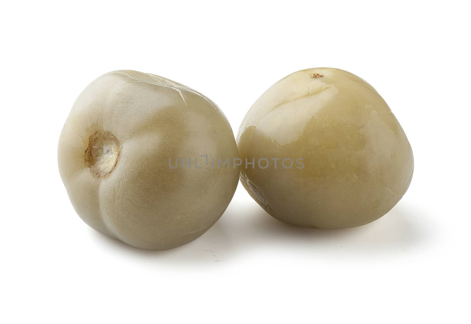 Two green marinated tomato on the white background