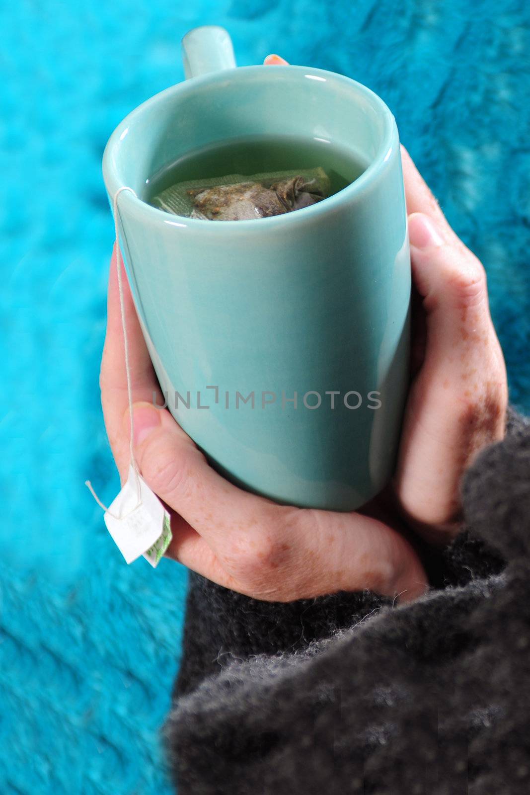 drinking tea in winter with blue mug and blanket