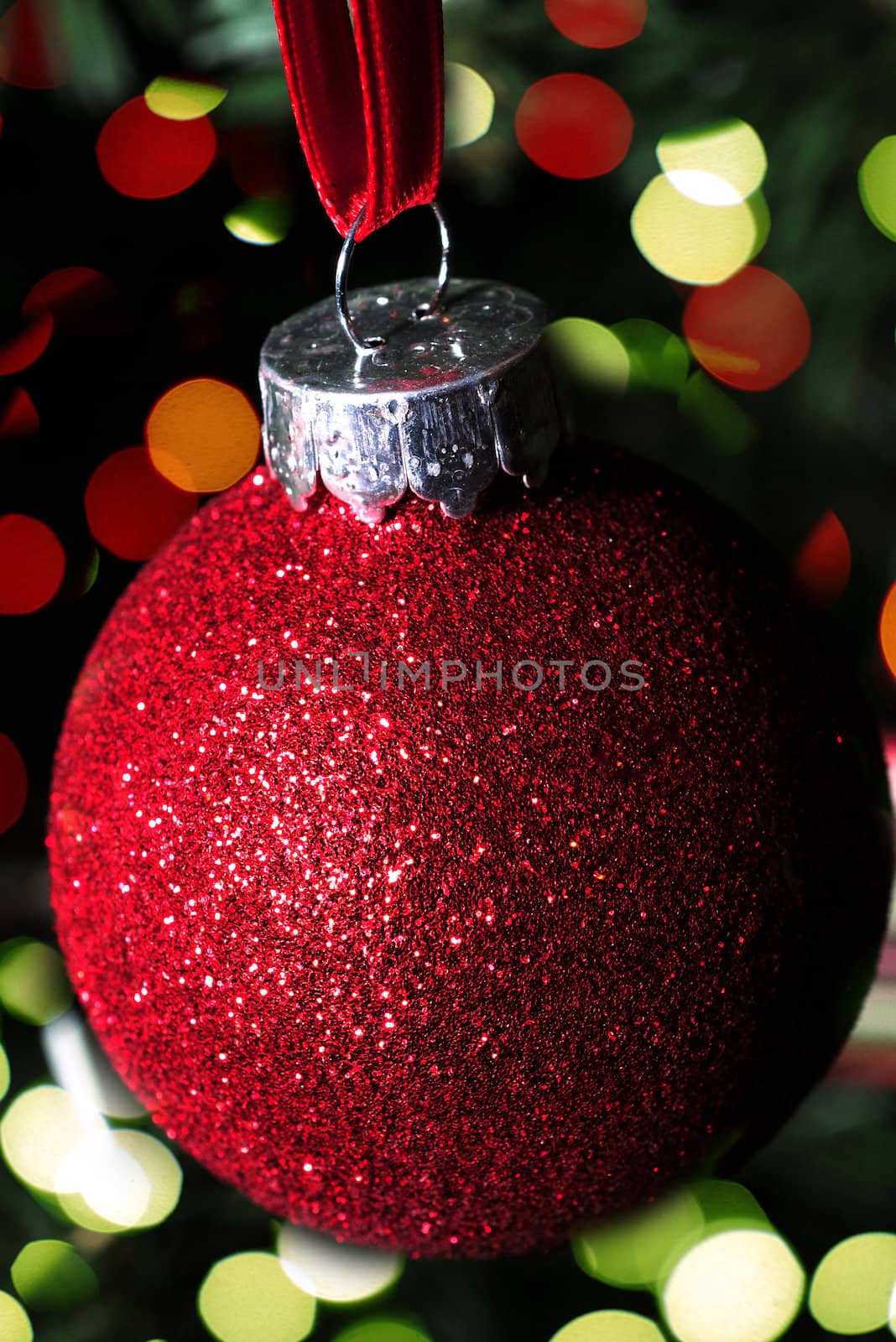 red glitter christmas ornament and christmas lights