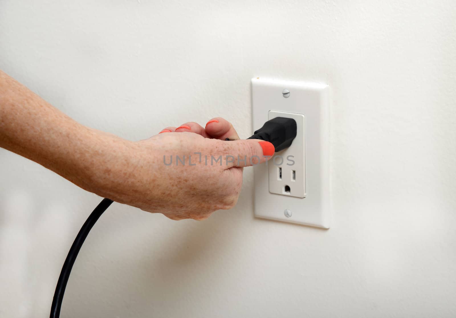 woman with orange fingernails pulling the plug