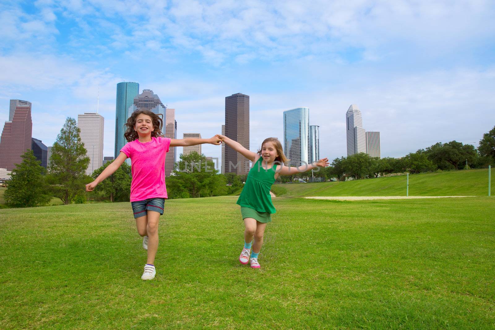 Two sister girls friends running holding hand in urban skyline by lunamarina