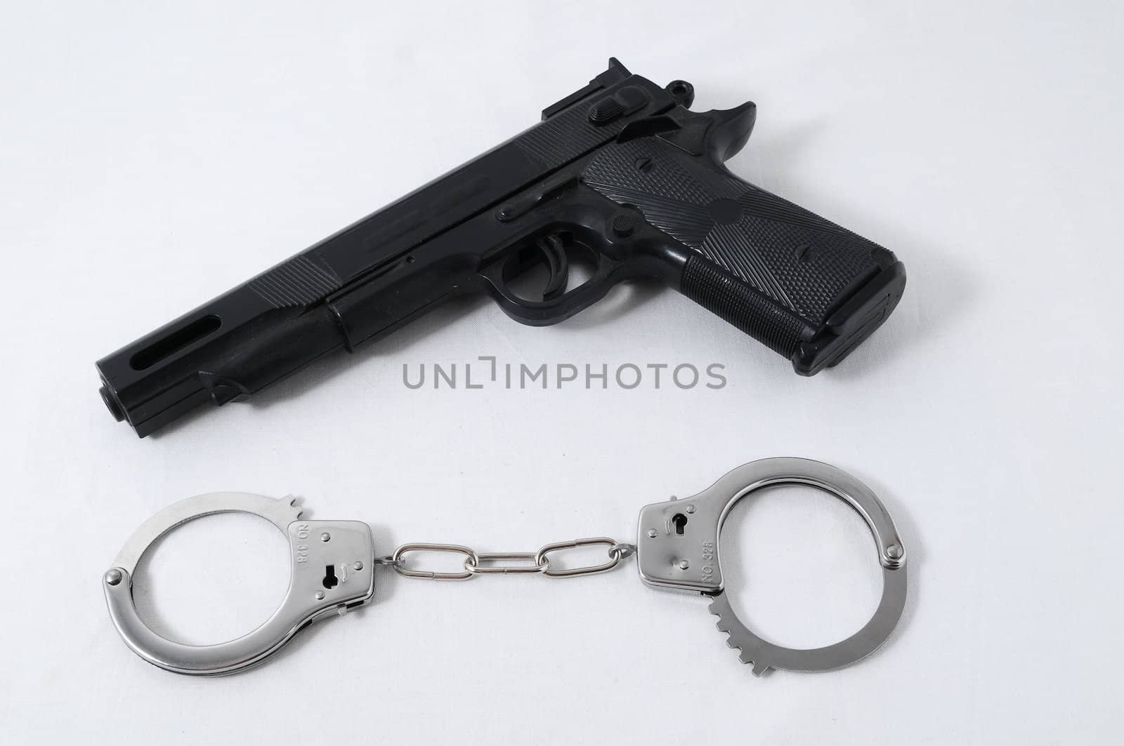 Criminality Concept Gun and Handcuffs on a White Background