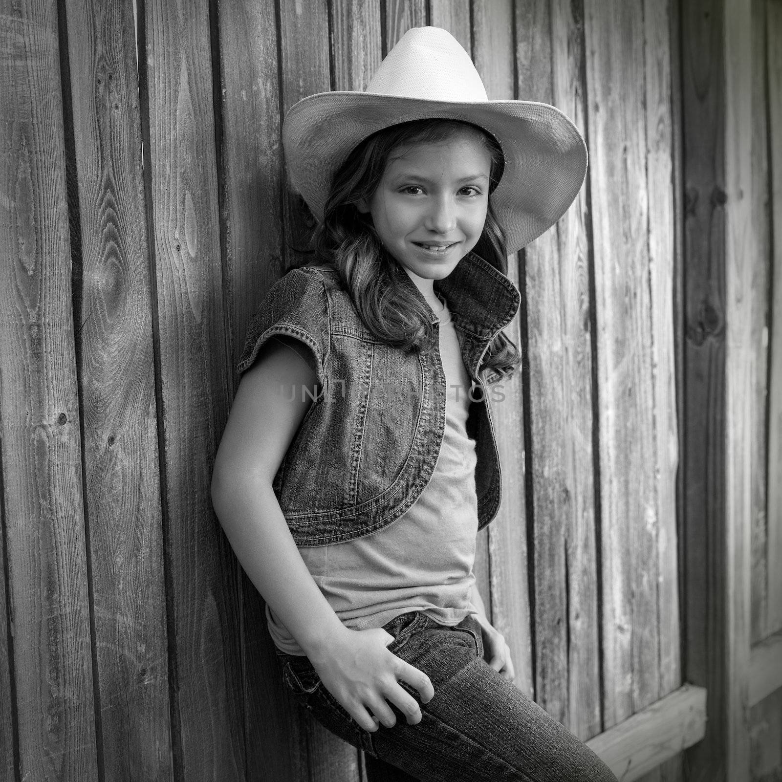 Children girl as kid cowgirl posing on wooden fence by lunamarina