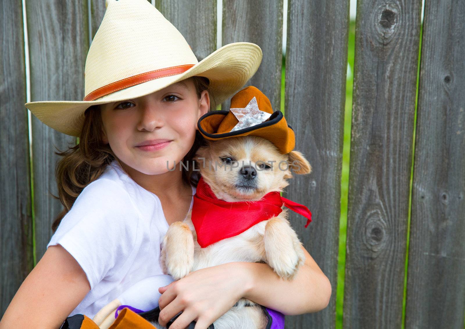 Beautiful cowboy kid girl holding chihuahua with sheriff hat by lunamarina