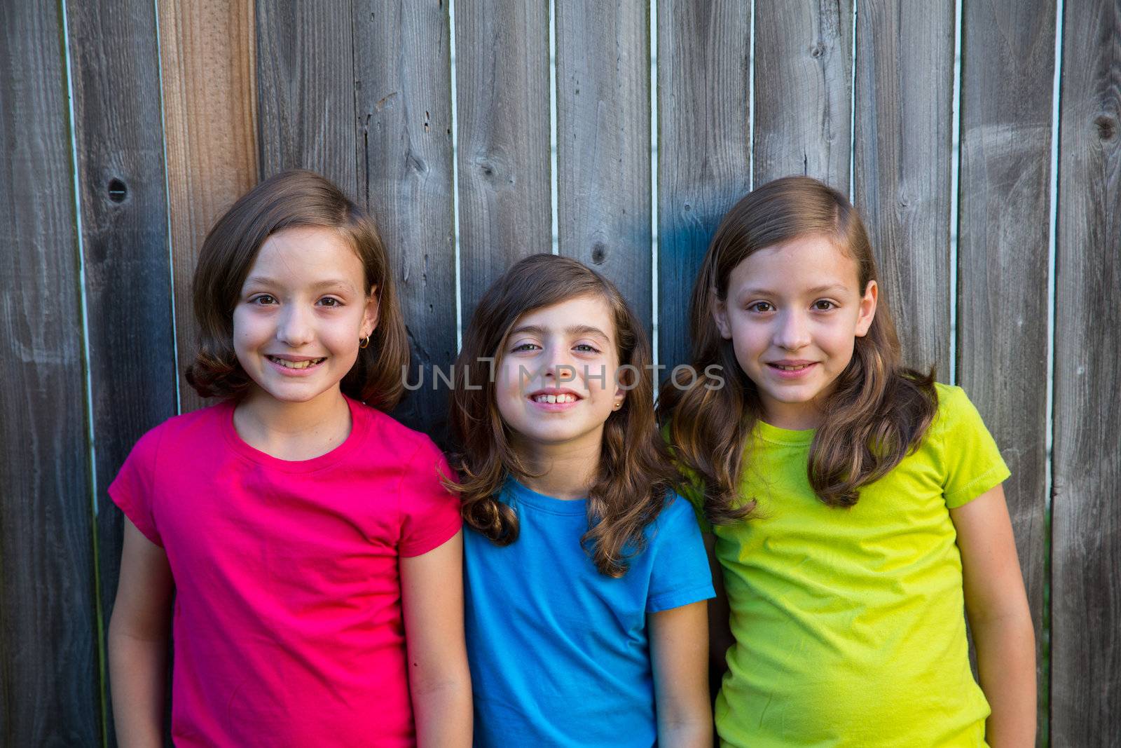 Sister and friends kid girls portrait smiling on gray fence by lunamarina