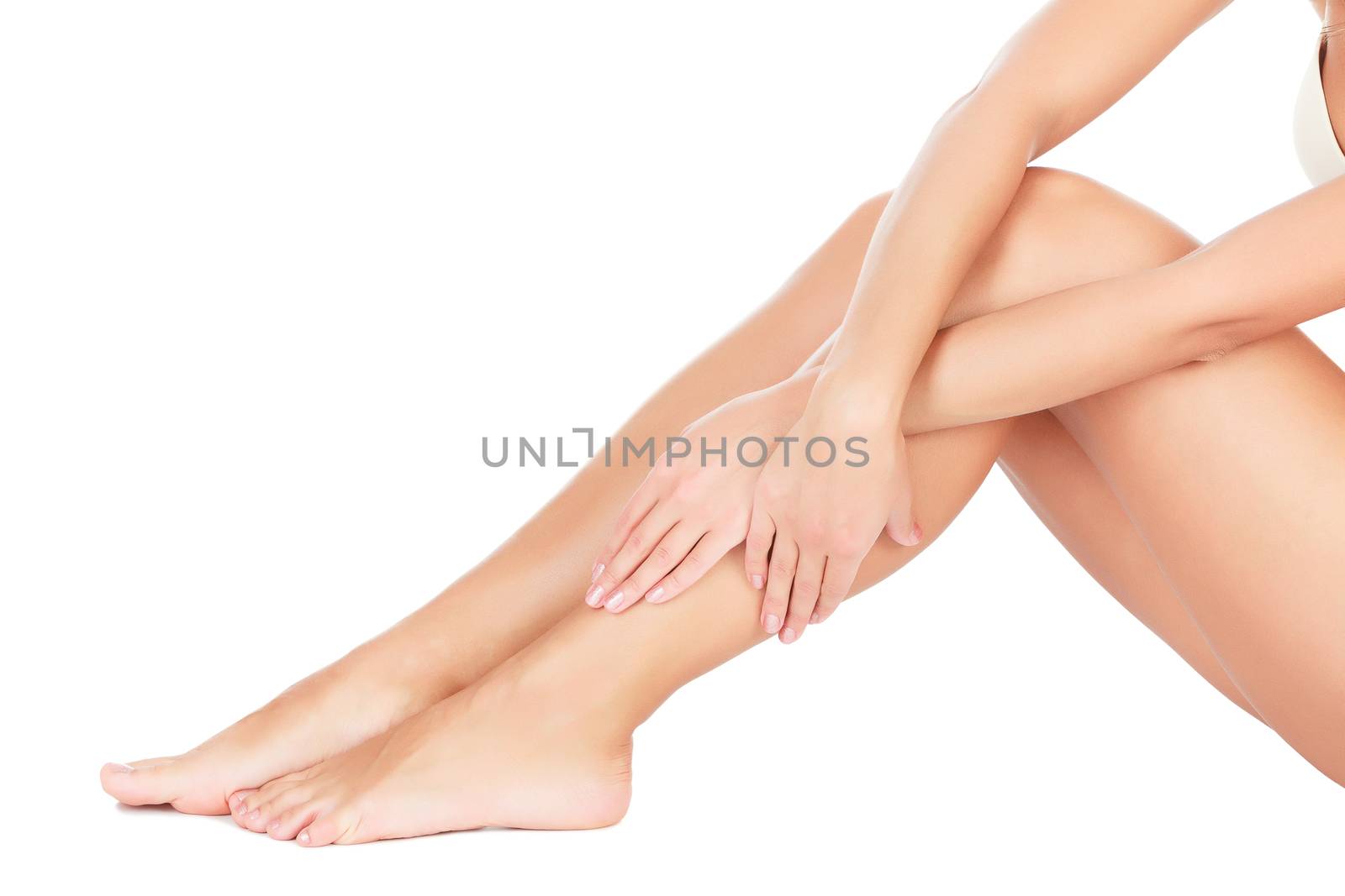 Woman touches her leg, white background, copyspace by Nobilior
