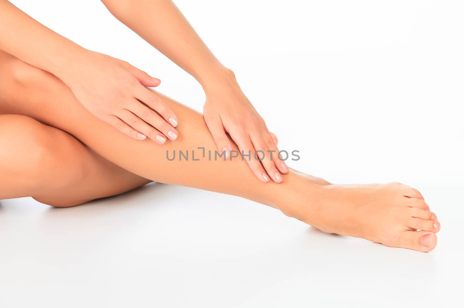 Woman touches her leg, white background, copyspace. by Nobilior