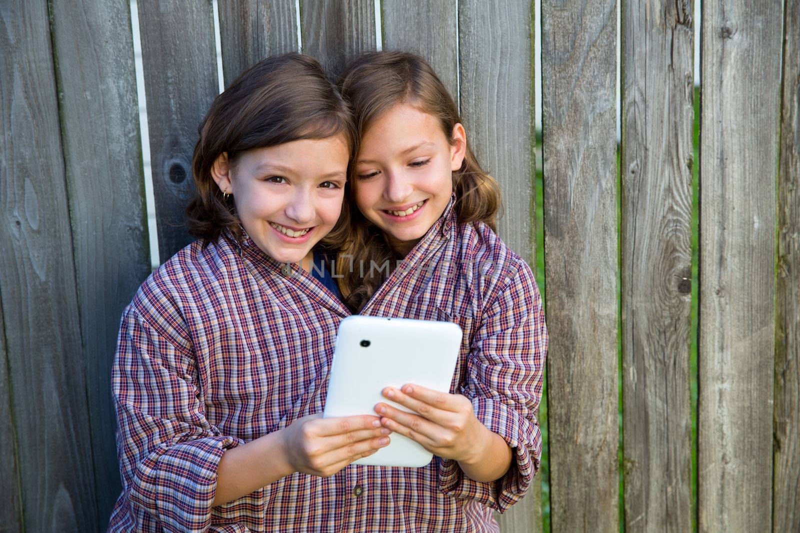 twin girls dressed up pretending be siamese and tablet pc by lunamarina