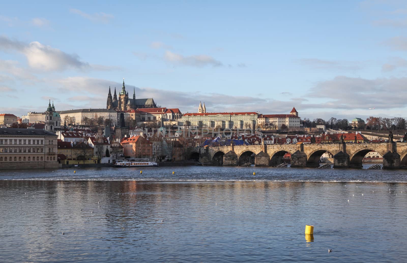 Prague, Czech Republic – January 02, 2013: View at the Prague Castle in Hradcany district and crowded Charles Bridge over the Vltava river in Prague, Czech Republic.