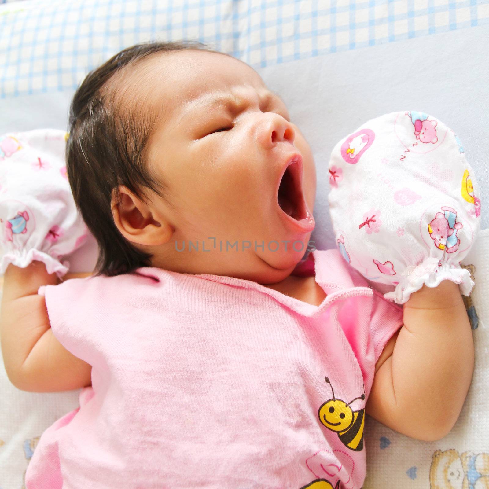 Newborn Asian baby girl lies on a blanket