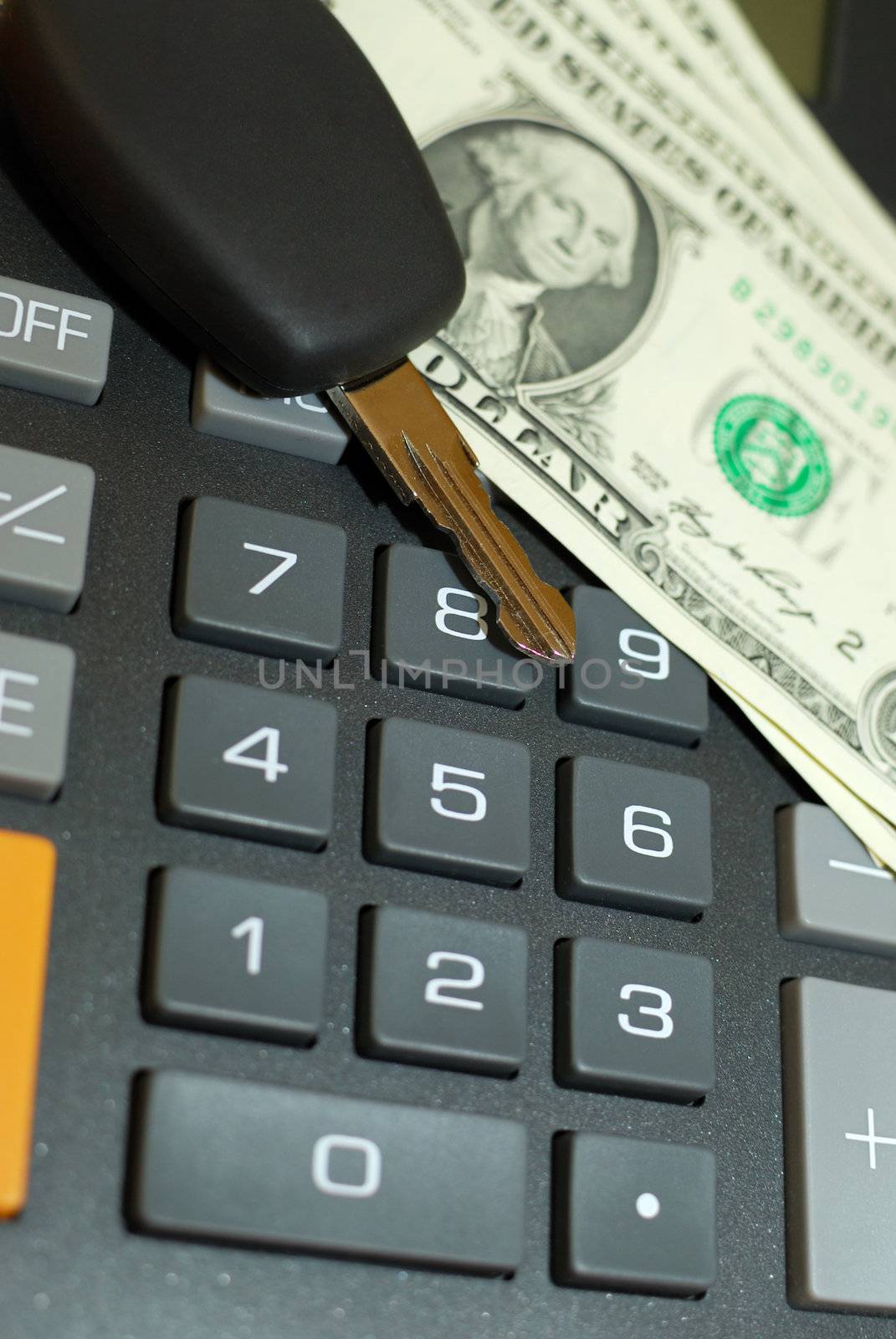 Car key and money on keypad of a calculator close up