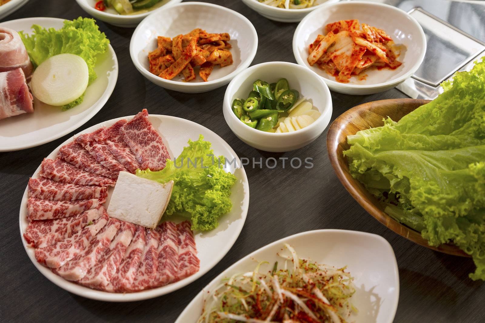 A horizontal shot of beef with korean side dishes.