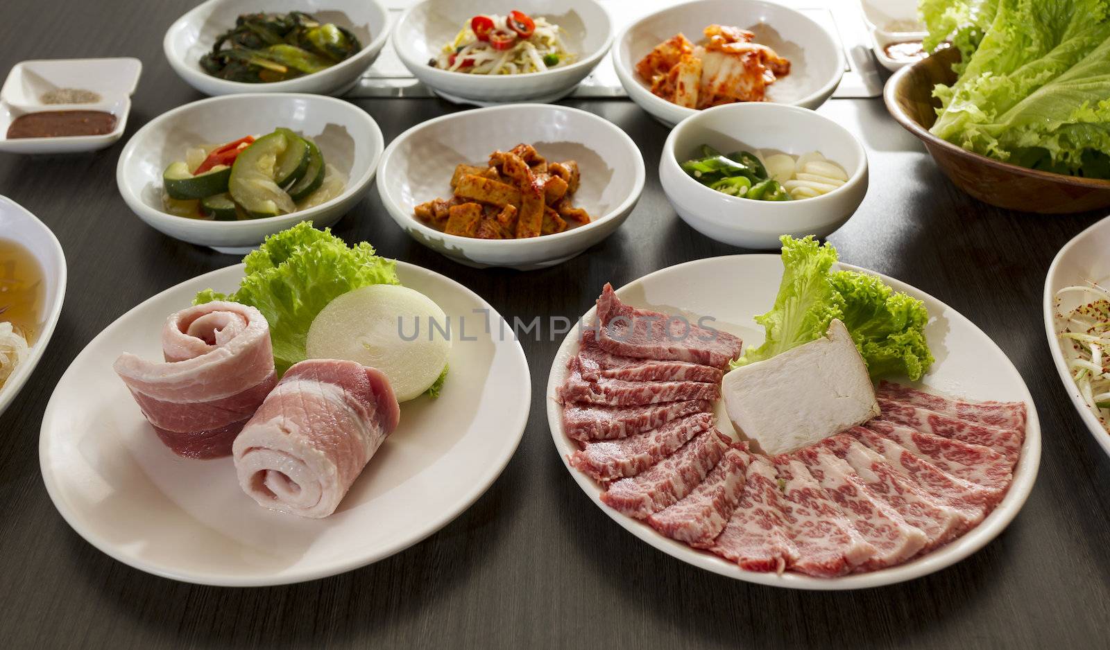 A horizontal shot of beef with korean side dishes.