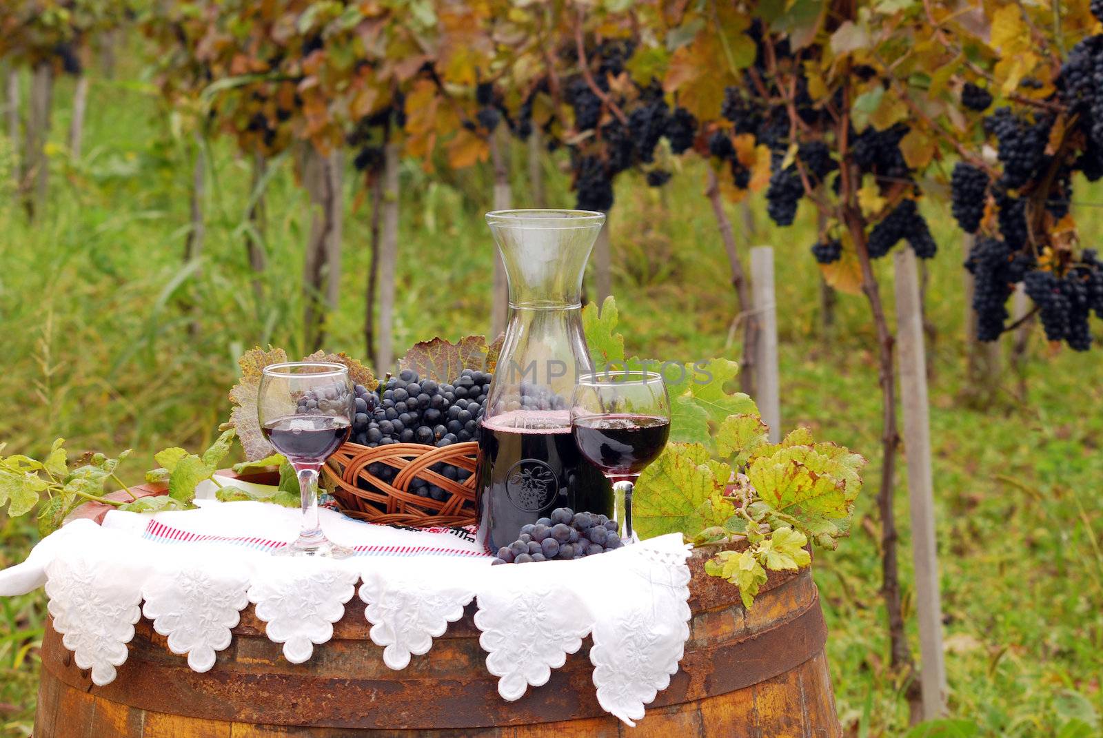 red wine and grape on wooden barrel