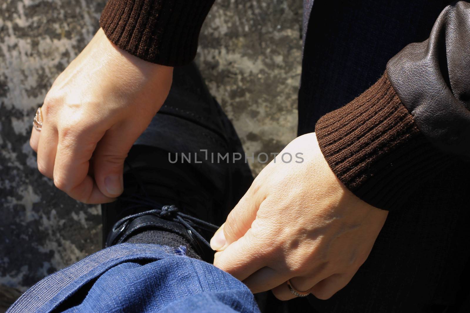 Woman tying a shoelaces on the mans shoes