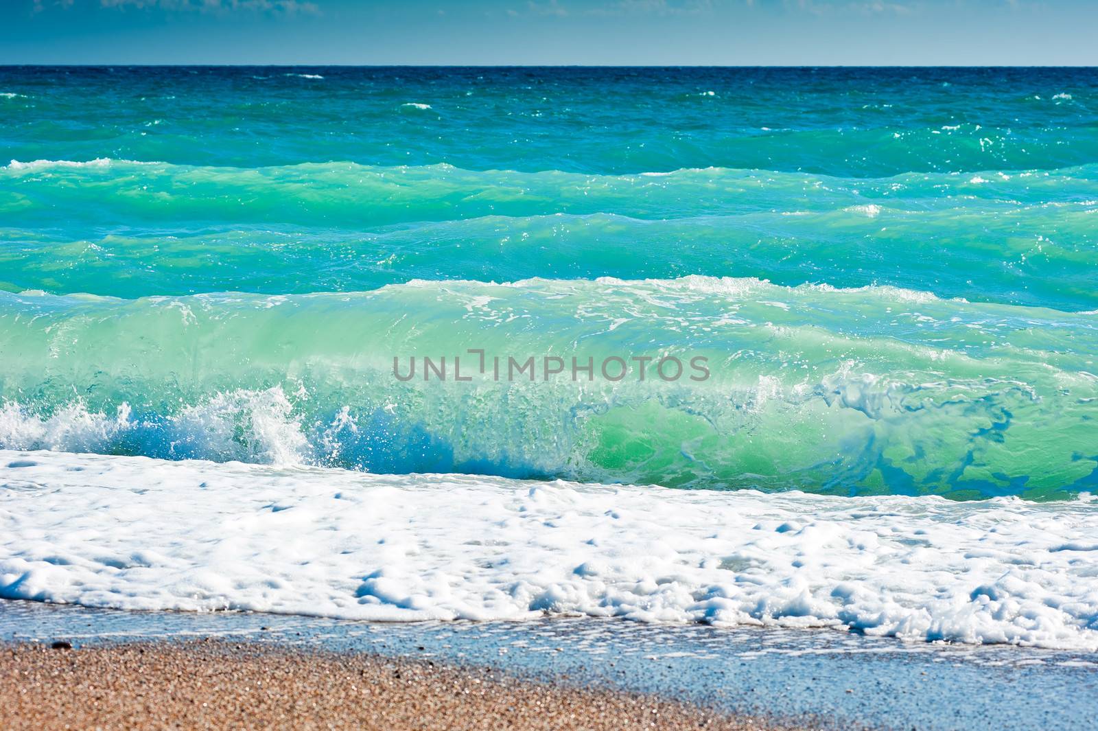Splash of sea foam on a sandy beach