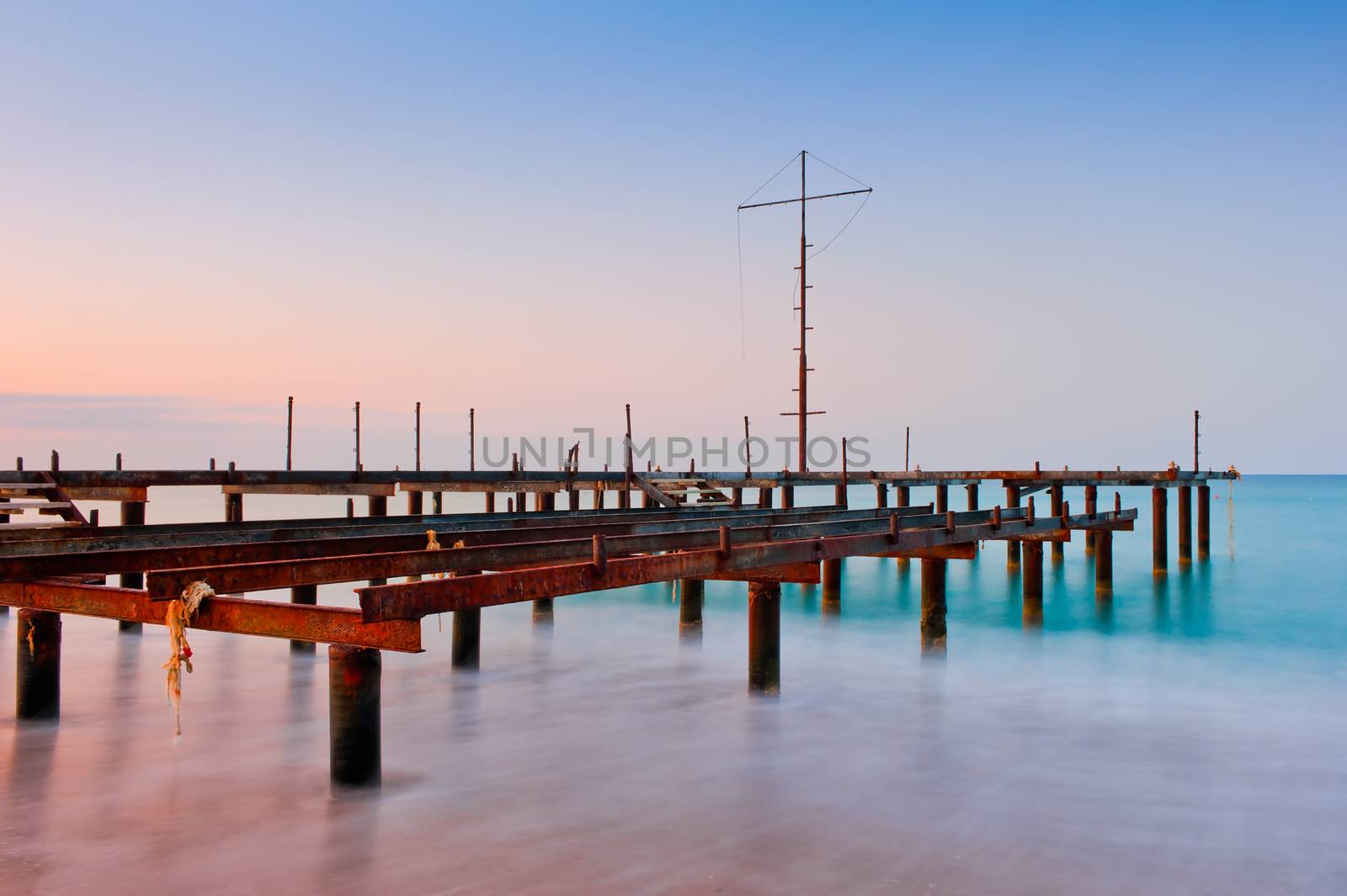 Old pier in the sea at dawn by kosmsos111