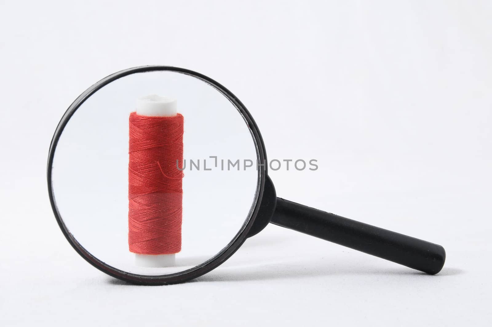 Roll of Twine and Loupe on a White Background