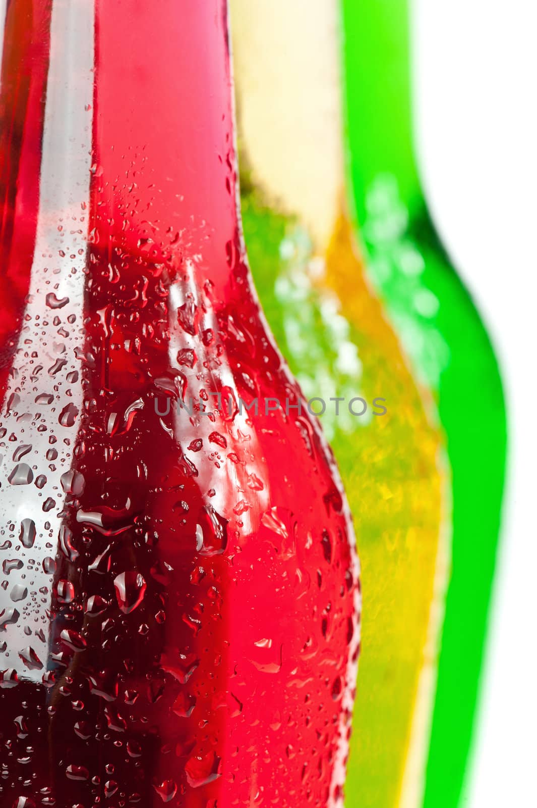 Assortment of cold bottles of pop or coolers on white background