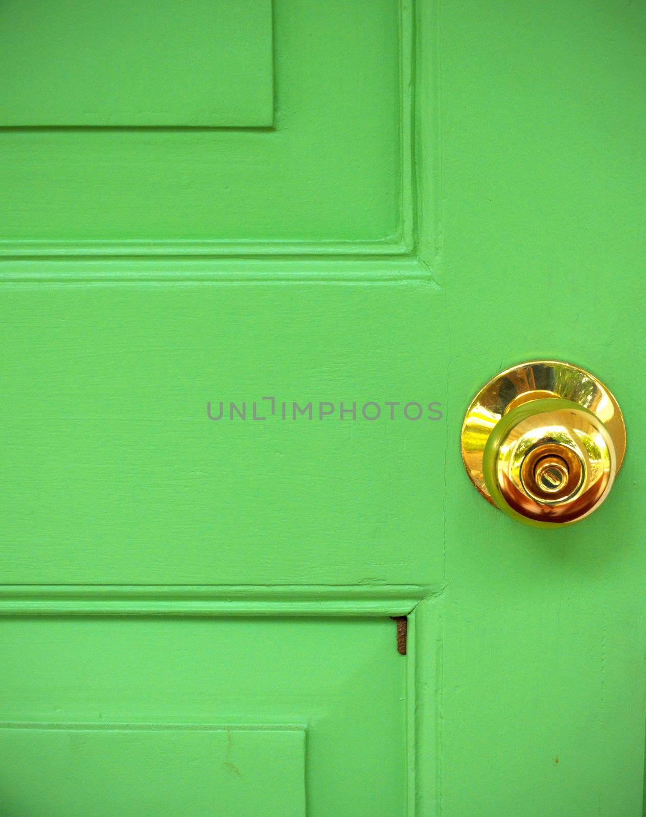 Gold door knob on green 