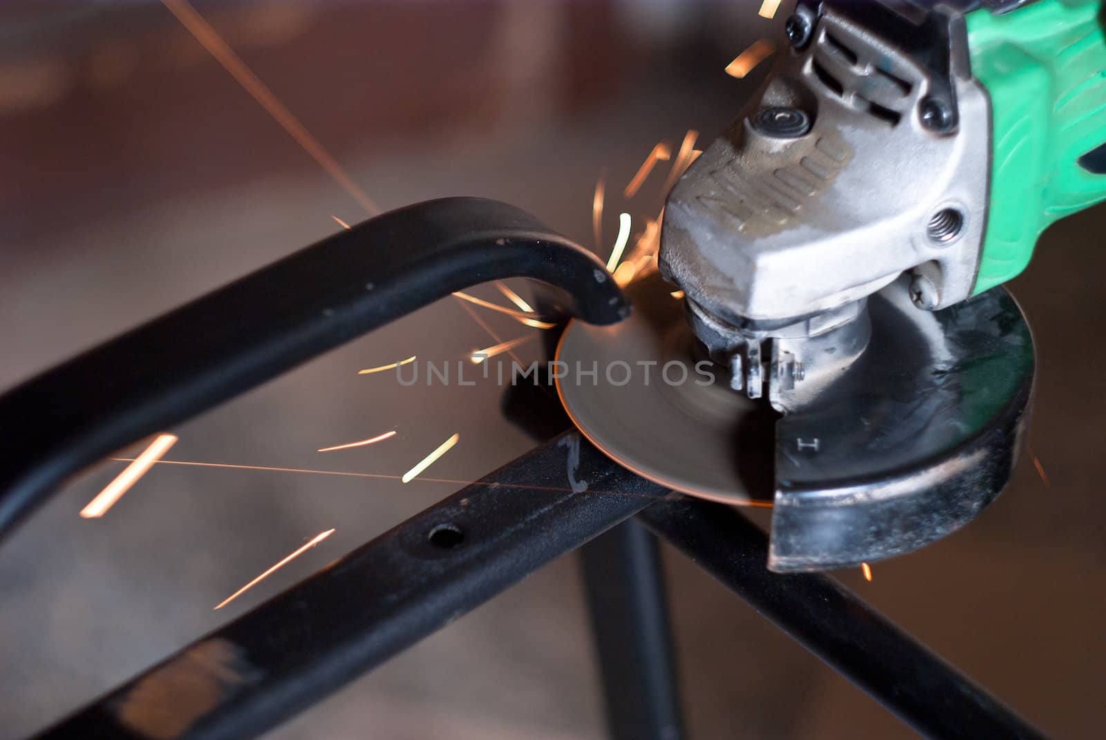 Worker cutting metal using angular grinding machine