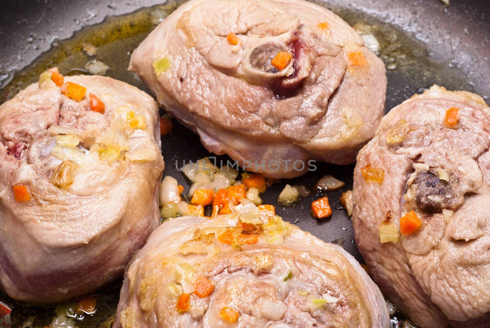 veal shank cooking in frying pan