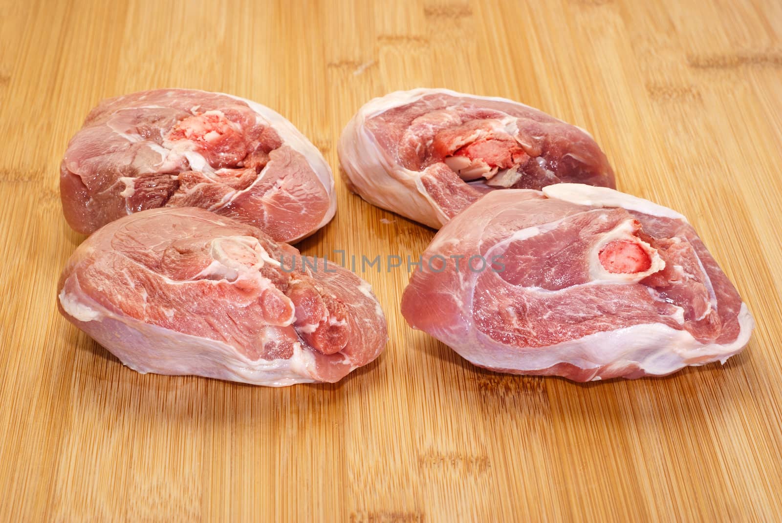 ossobuco (bone-in lamb shank steaks) on a wooden chopping board