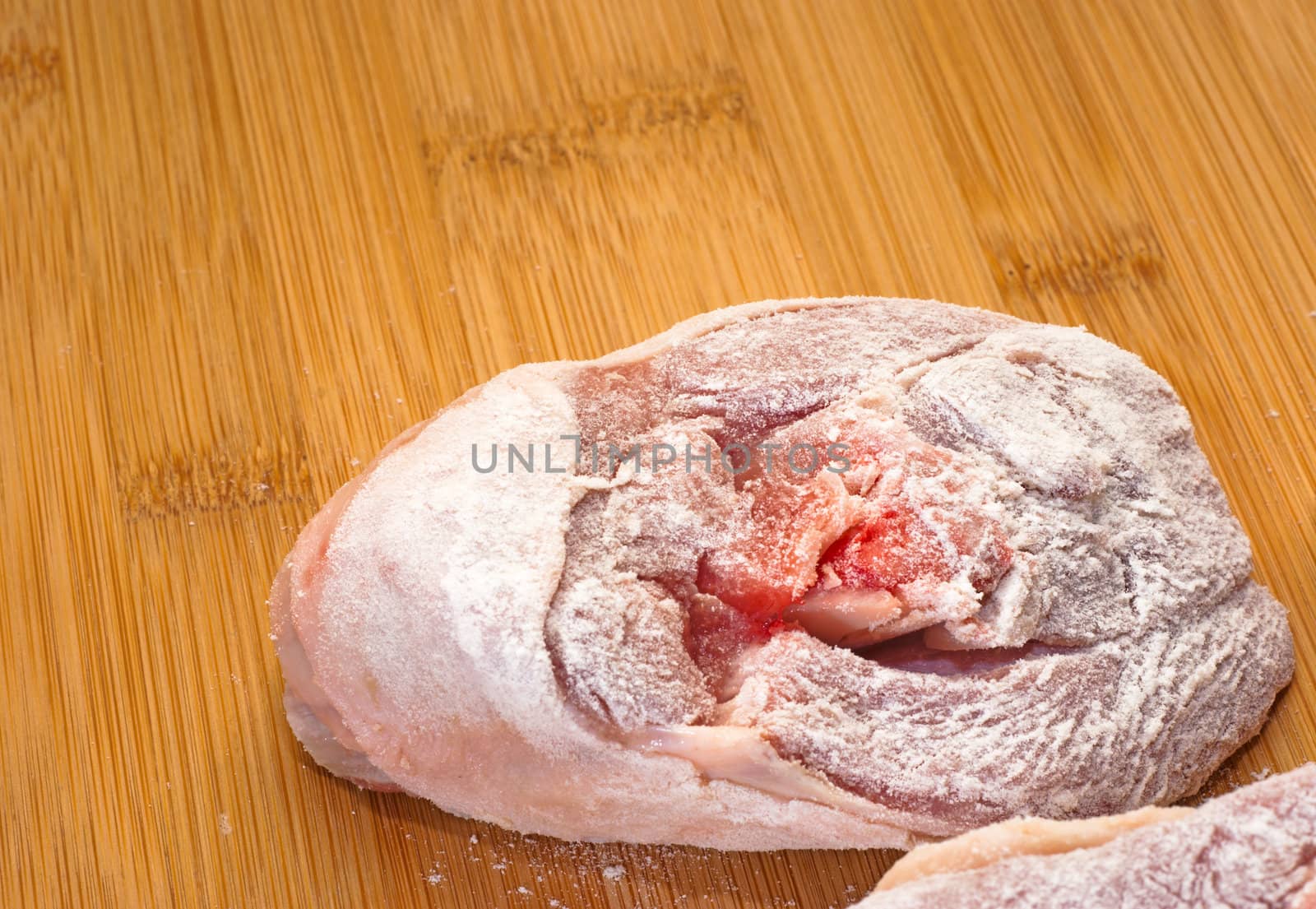 ossobuco floury (bone-in lamb shank steaks) on a wooden chopping board