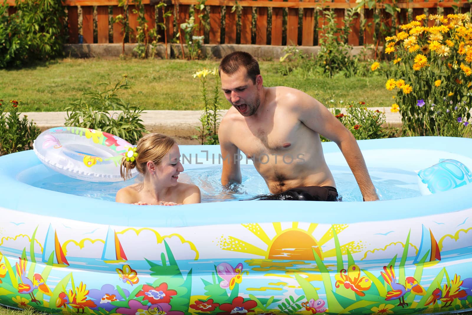 young pair bathes in inflatable pool