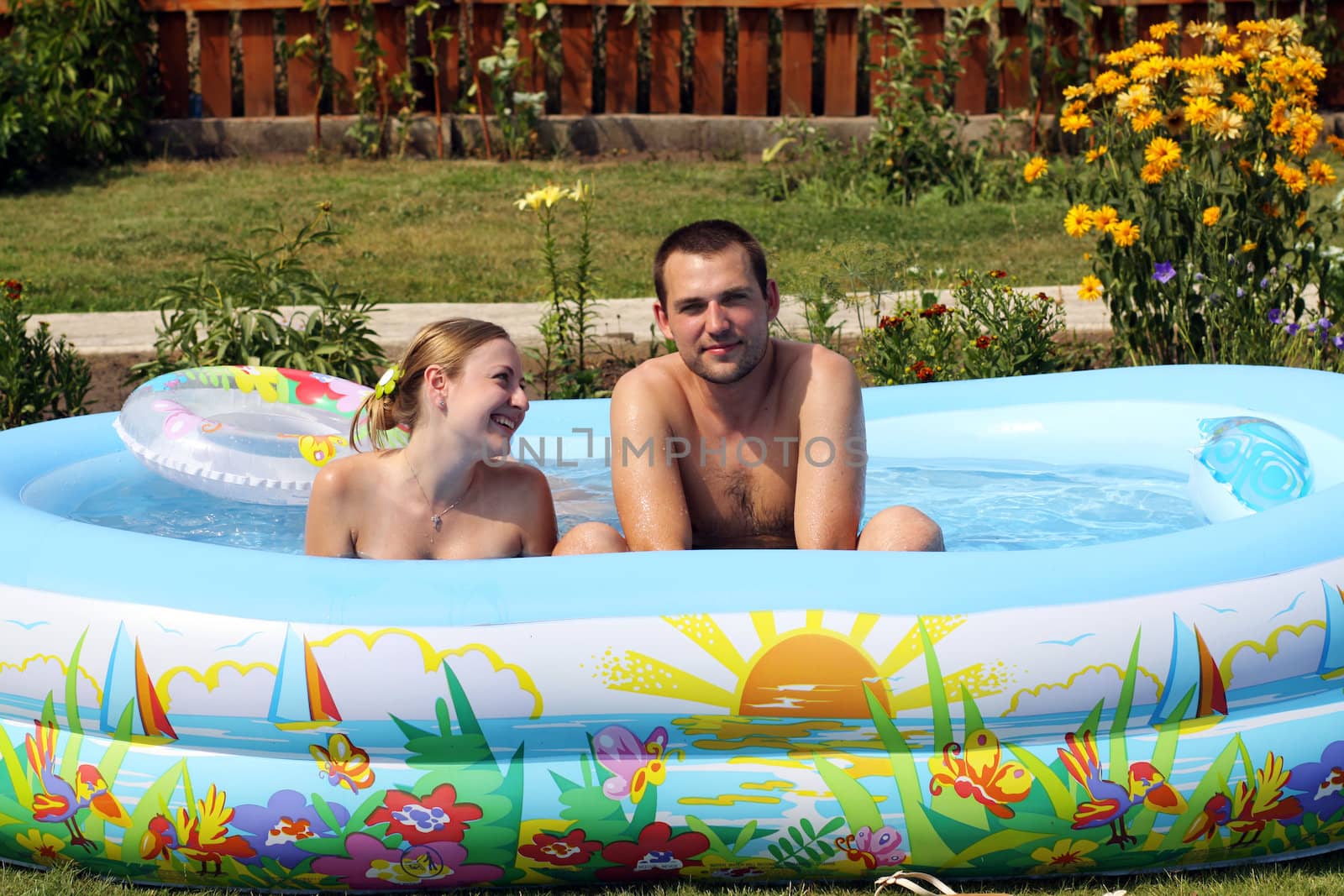 young pair bathes in inflatable pool