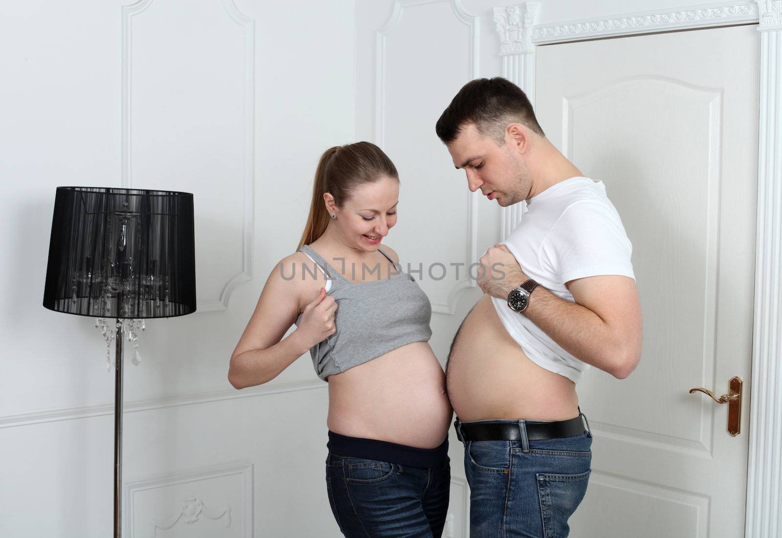 Man and pregnant woman is showing their bellies by andersonrise