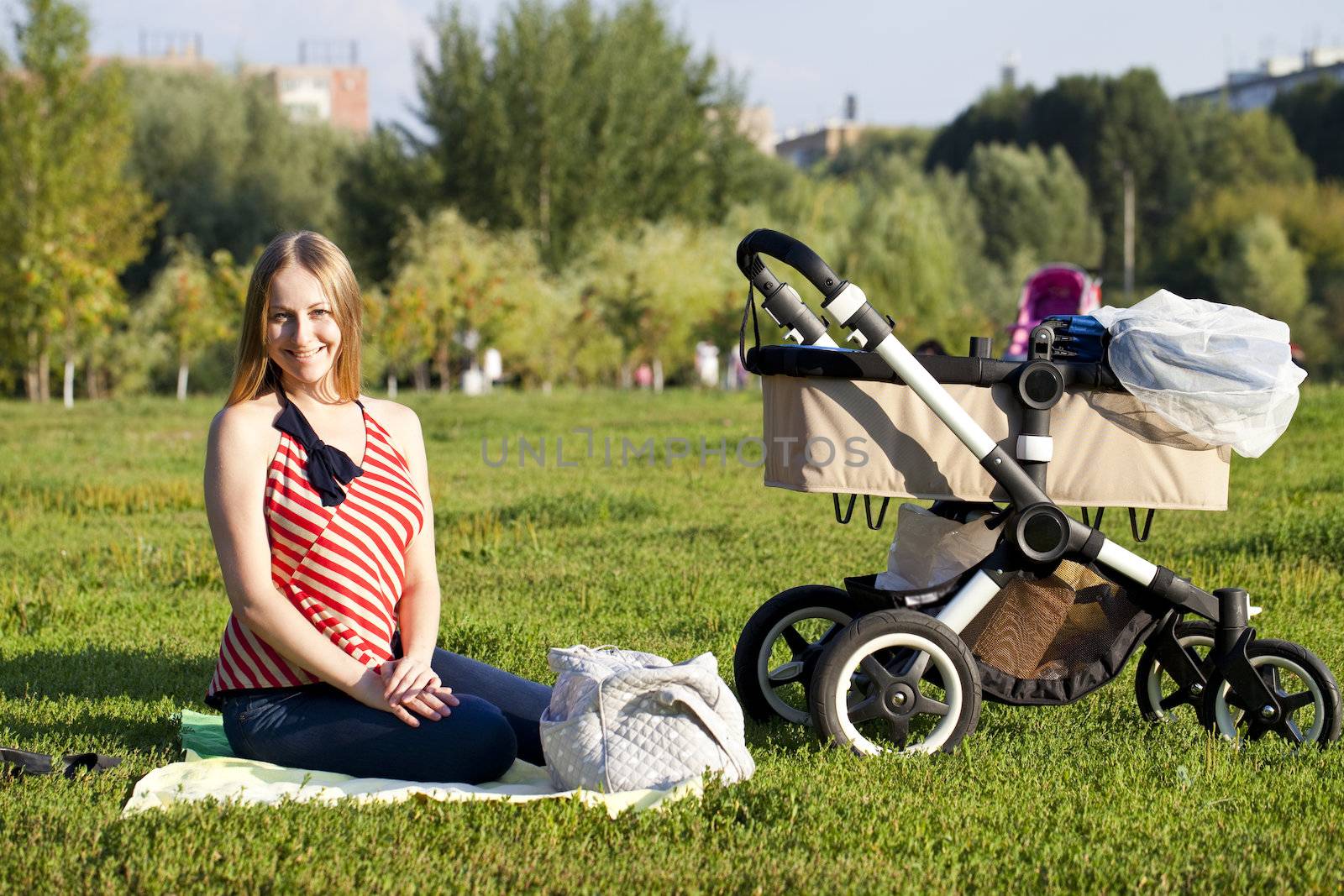 Young mother with baby stroller for a newborn