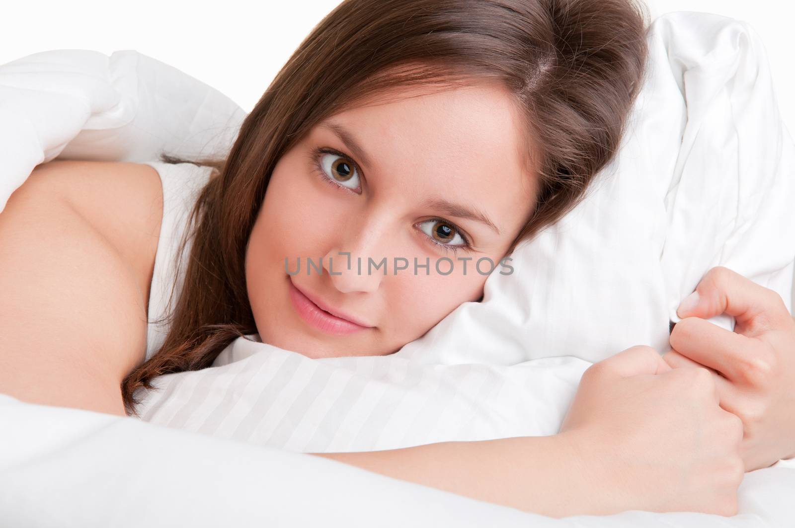 Woman in her bed, resting her head on a pillow