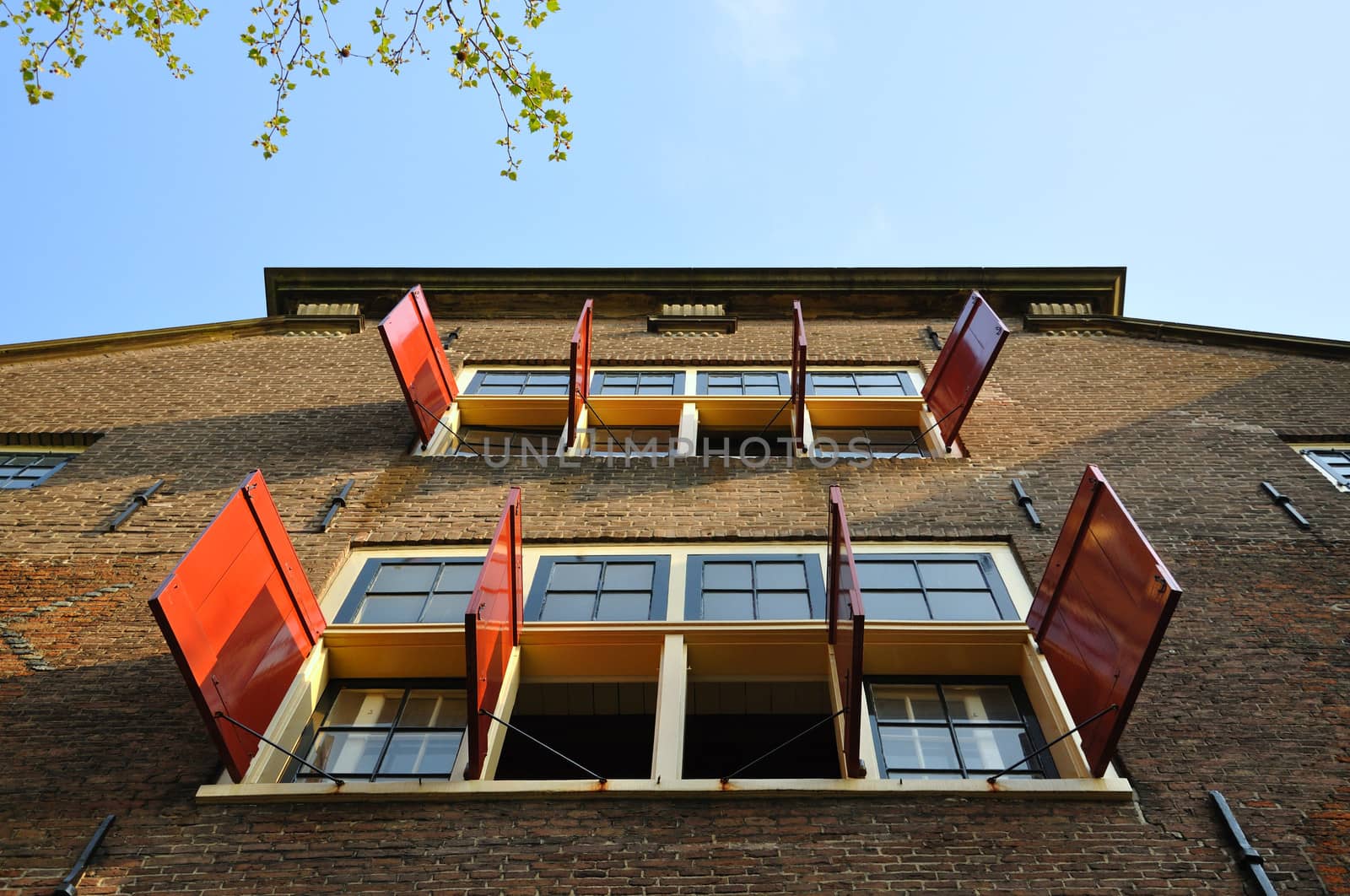 Beautiful building with open sun blinds and windows in Amsterdam, Holland (Netherlands)