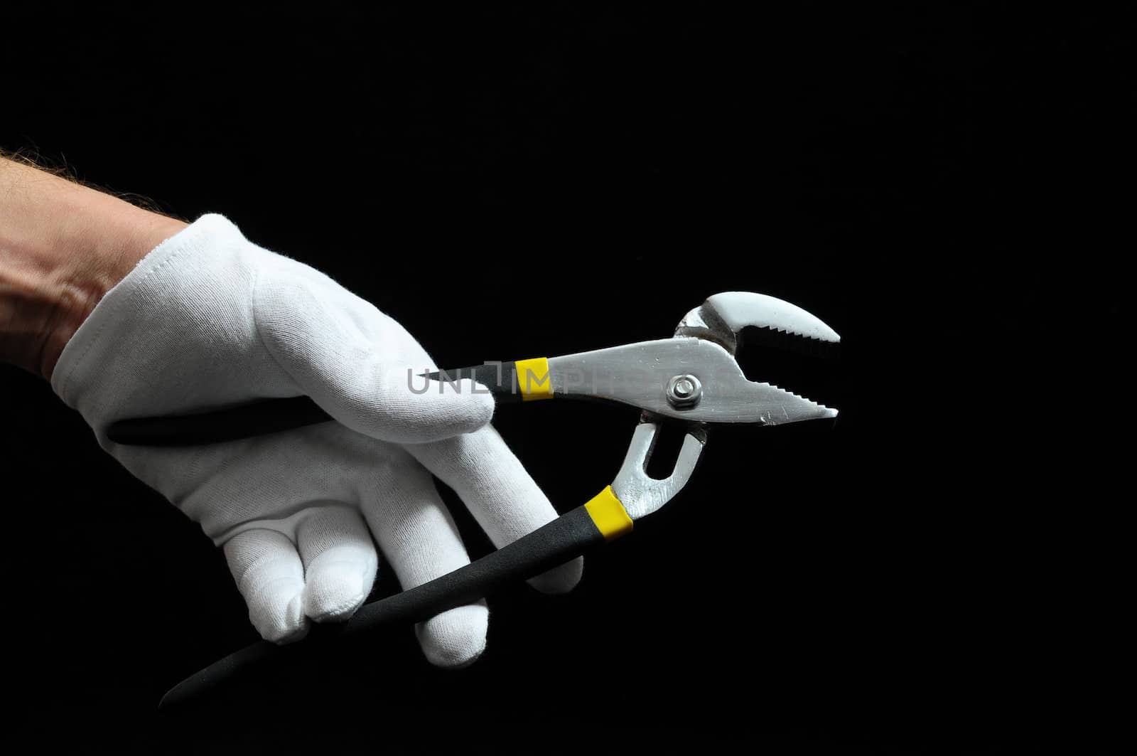 Pliers and a Hand on a Black Background