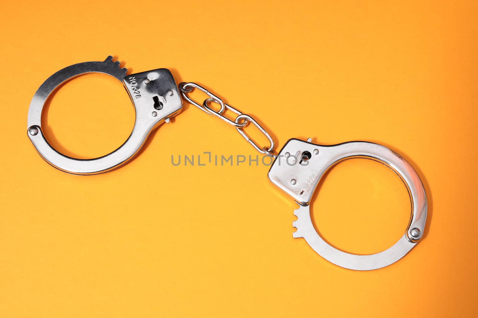 One Pair of Handcuffs on a Colored Background